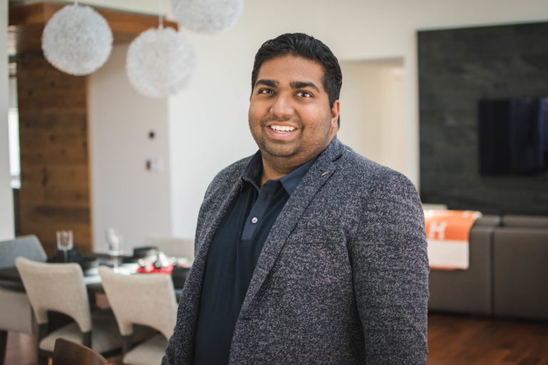 Rikhil Amin poses for a photo in a living room.