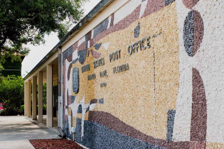 Colorful yellow, red, and blue mural made of painted rocks